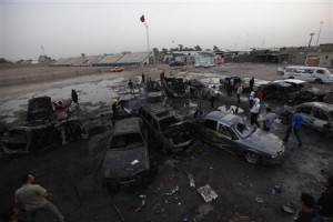 Residents gather at the site of bomb attacks in Baghdad